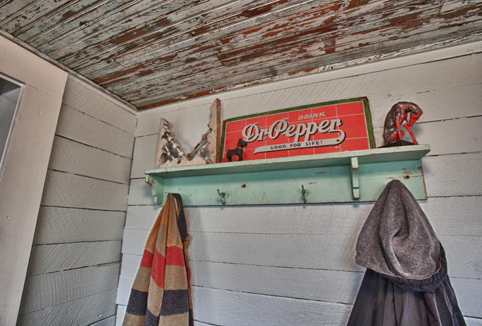 Living Vintage - Mudroom coat rack with old signs, corbels, and an antique dog 