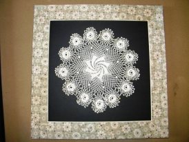 Antique doilies framed using reclaimed wallpaper