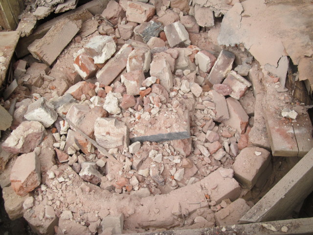 brick shards and dust fill in the old well