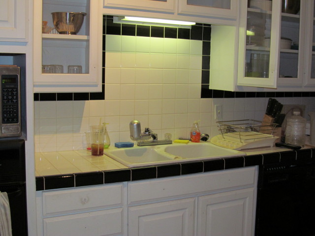 our kitchen before:  a sink facing a tile wall