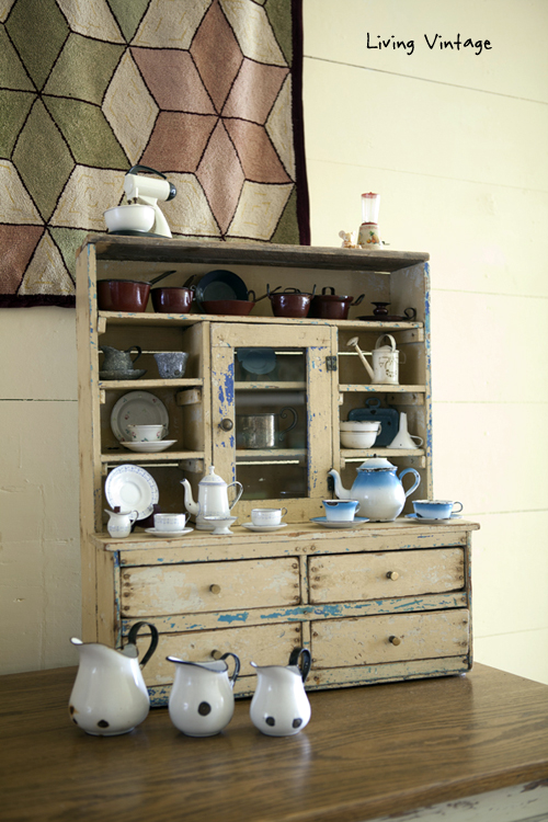 miniature enamelware in a cabinet and an antique rug - Living Vintage