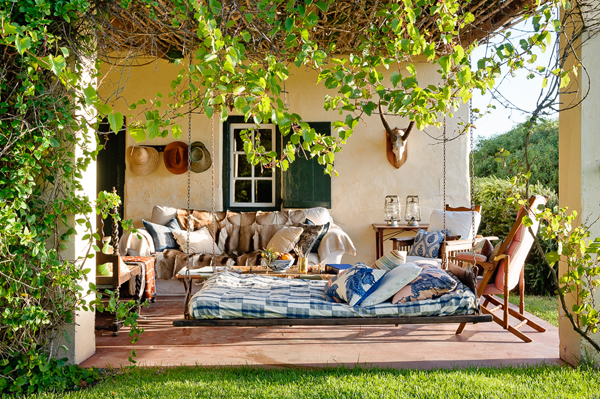 a wonderful porch with comfy seating and a hanging bed - Friday Favorites - Living Vintage
