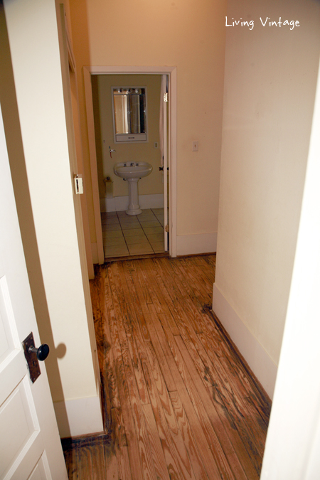 The narrow hallway which led to the original (and only) bathroom.  Two closets are on the right and the third is on the left.