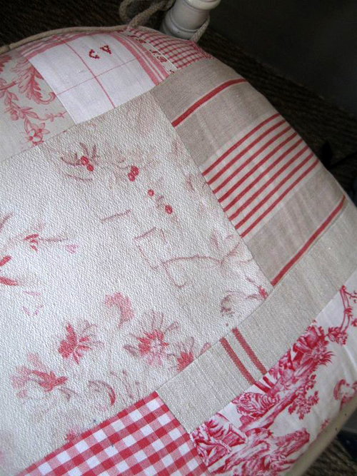 a chair cushion upholstered in an antique linen patchwork