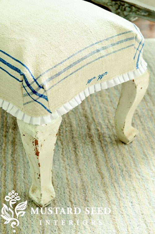 an ottoman slipcover made using a vintage tea towel