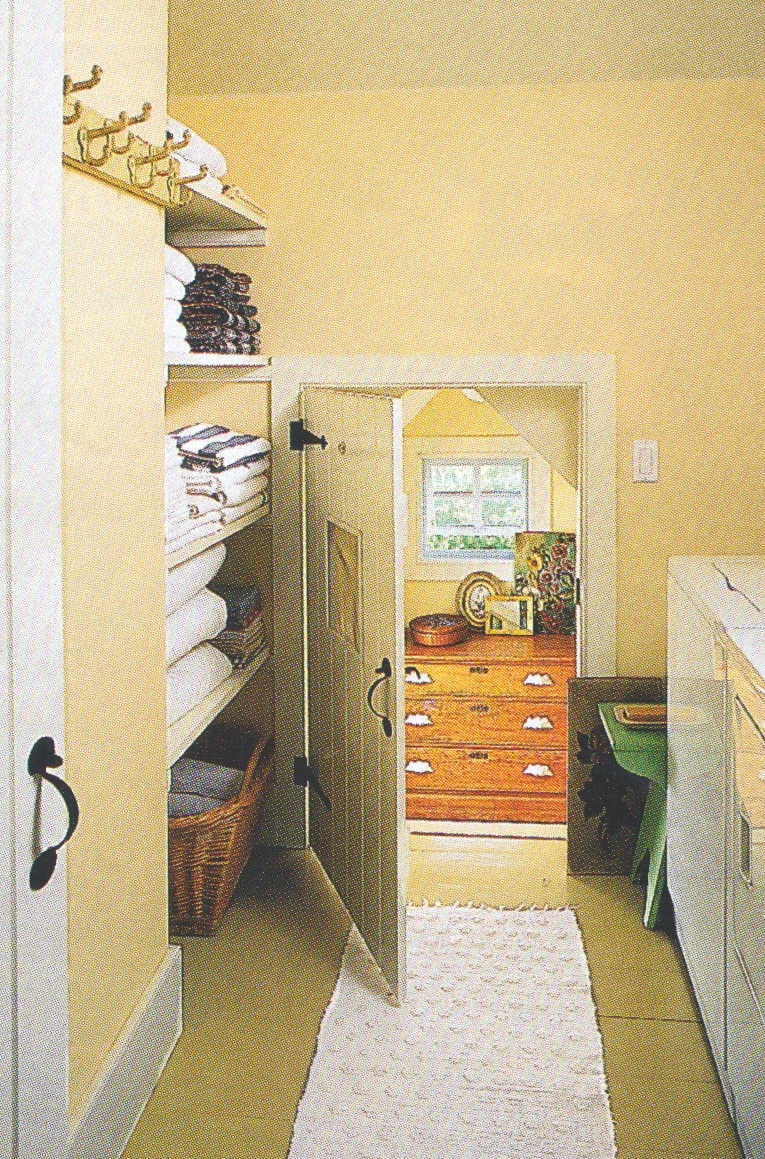 a small but very functional laundry room with linen storage nearby